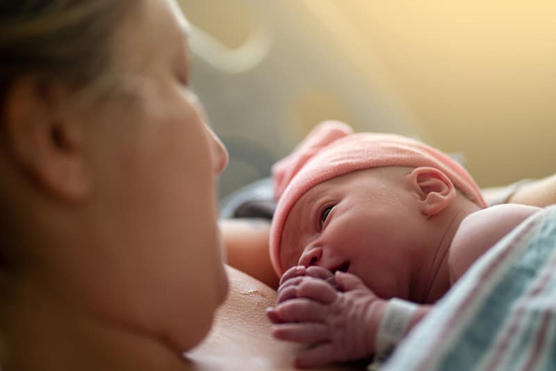 mother smiling at newborn