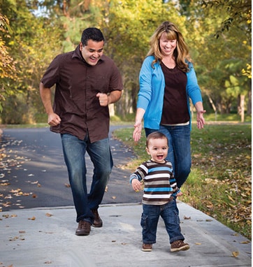 mom and dad playfully running with toddler